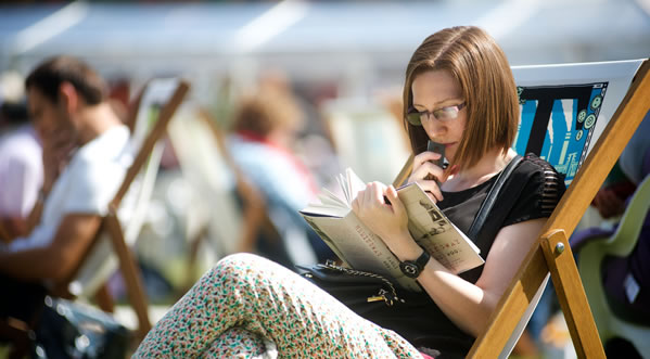 Woman in a deckchair reading a book outside
