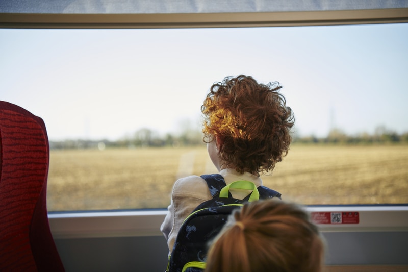 Young boy looks out of the train window
